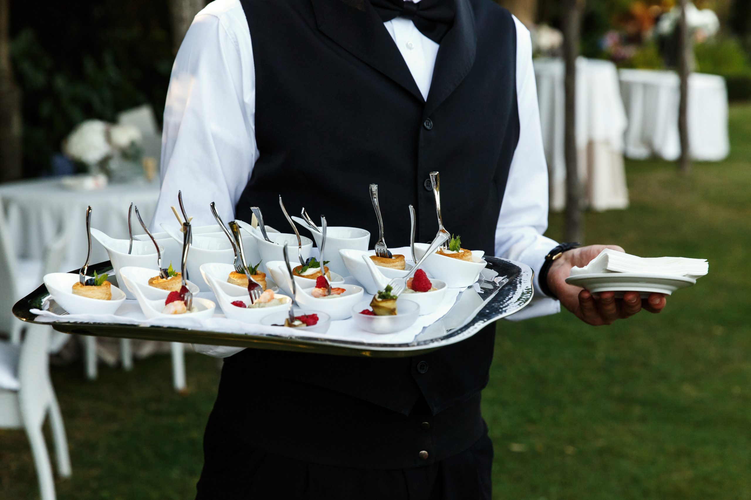 waiter carries plate with tasty snacks scaled